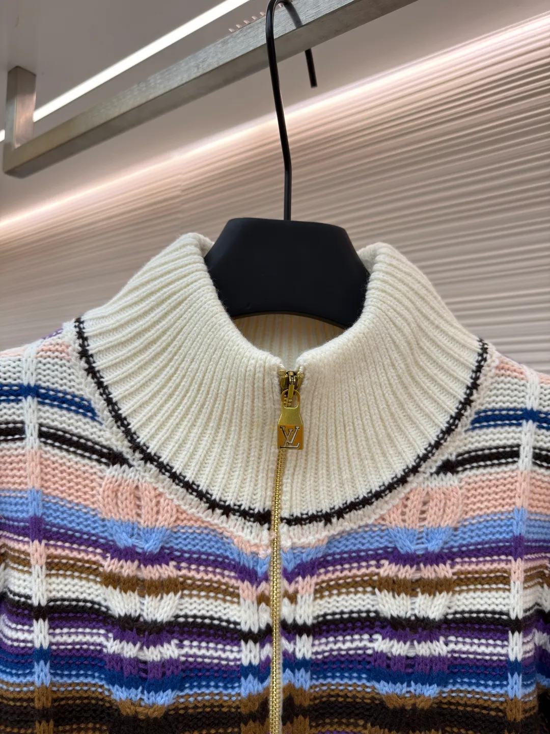 LOUIS VUITTON letter badge color block cable zipper knitted jacket ●Original version: purchased and developed by 21570 ●Item number: 1682322-C15 ●Fabric: wool blended fabric ●Technology: knitting ●Color: pattern ●Version: fitted version ●Weight: about 710 grams ●Size: S-M-L-XL ●Description: This Louis Vuitton color-blocked striped knitted cardigan is made of merino wool and cashmere blended yarn and is woven on a 12-needle coarse-gauge computerized flat knitting machine. The body is interlaced with cable knitting and plain knitting. The stripes are directly knitted with colored yarns instead of post-printing and dyeing. The ratio of colored yarns for each stripe is accurately calculated, making the color transition natural and not easy to fade. The placket is equipped with a customized brass zipper, and the zipper teeth are polished and gold-plated, which is both smooth and durable. The leather label on the left chest is fixed with first-layer calfskin through heat embossing process, and the edges are hand-polished without burrs. The neckline is designed with a high-elastic ribbed stand-up collar, which is not easily deformed after being shaped at high temperatures. The ribbed edges on the cuffs and hem are woven with double-strand yarn, which is more elastic. The shoulders are seamlessly woven with raglan sleeves to reduce the feeling of seams rubbing against the skin. The overall loose fit is combined with three-dimensional tailoring, which not only retains the soft texture of knitting, but also creates a crisp silhouette. Each piece is hand-ironed and quality-checked by brand craftsmen. The overall wiring is straight and delicate, the fabric is comfortable and soft, and the color is consistent without color difference. It can be matched with the same style to create a fashionable look and control various occasions. Customized accessories, complete with three standards, same style for men and women!